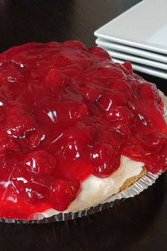 a pie with cherries on it sitting on a table