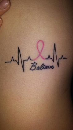 a woman's stomach with a pink ribbon and heartbeat tattoo