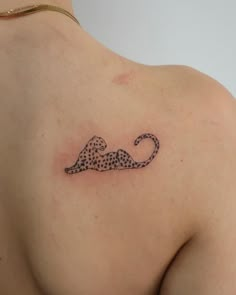 a cheetah tattoo on the back of a woman's left shoulder and chest