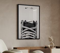 a black and white photo of a pair of shoes hanging on the wall above a chair