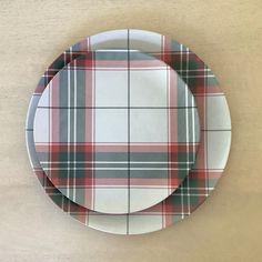 a plate with a red and green plaid pattern on it sitting on top of a wooden table