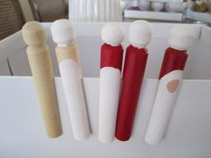 four toothbrushes are lined up in a holder on the counter, one is red and one is white