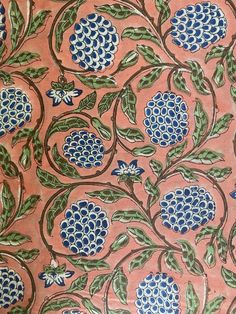 an intricately designed wallpaper with blue flowers and green leaves on pink ground,