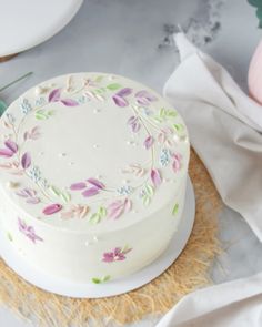 a decorated cake sitting on top of a table next to other plates and utensils