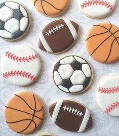 decorated cookies in the shape of sports balls and basketballs on a white tablecloth