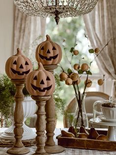 three carved pumpkins sitting on top of a wooden stand in front of a window