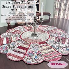 a quilted table topper on a dining room table with a candle in the center