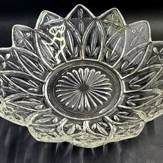 an ornate glass bowl on a black table