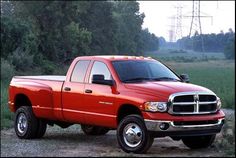 a red dodge ram truck parked in the dirt