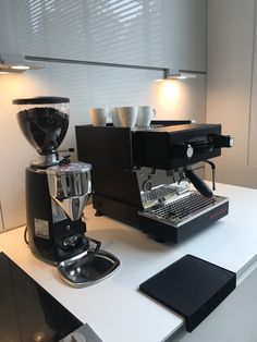 an espresso machine sitting on top of a counter next to a coffee maker