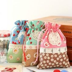 three small draws are sitting on a table with sewing supplies and thread spools