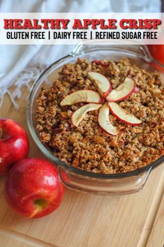 an apple crisp in a glass dish on a wooden cutting board with apples around it