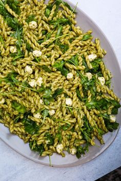 a white plate topped with pasta and spinach