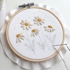 a close up of a embroidery on a piece of cloth with flowers in the middle