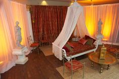 a bedroom with red and white decor on the walls, flooring and curtains around it