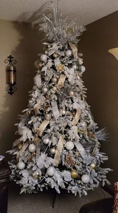 a white christmas tree with silver and gold decorations