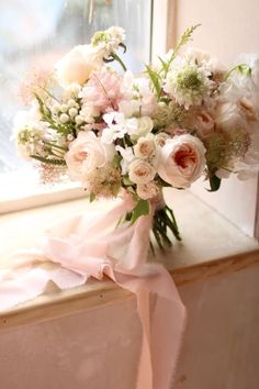 a bouquet of flowers sitting on top of a window sill