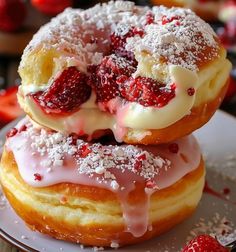 two donuts covered in icing and strawberries are stacked on top of each other