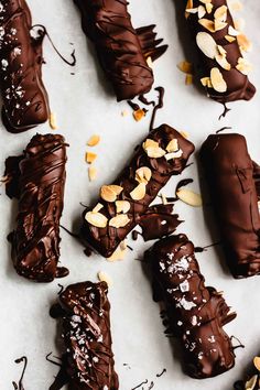 chocolate covered desserts with nuts and almonds on a white table top, ready to be eaten