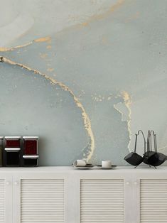 a white shelf with two cups and saucers on it next to a blue wall