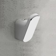 a computer mouse mounted to the side of a wall with concrete walls in the background