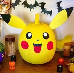 a pumpkin decorated like a pikachu with eyes and ears on it, surrounded by other halloween decorations