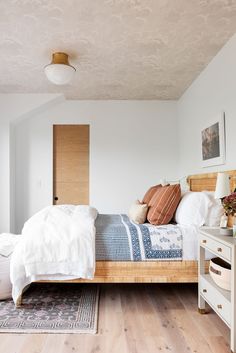 a bedroom with wood floors and white walls