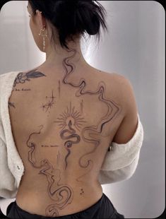 the back of a woman's body with tattoos on her upper and lower back