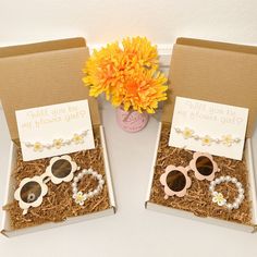 two boxes with sunglasses and flowers in them