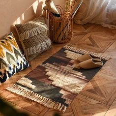 a rug with fringes on the floor next to a basket and other decorative items