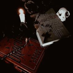 a book with a skull on it next to two candles