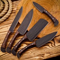 four knives are sitting on top of a wooden table next to a rope and wood board