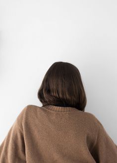 a woman standing in front of a wall with a clock on it's side