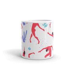 a white coffee mug with red and blue designs on the inside, in front of a white background