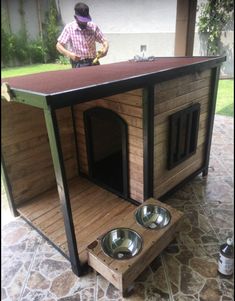 a dog house with two bowls on the outside