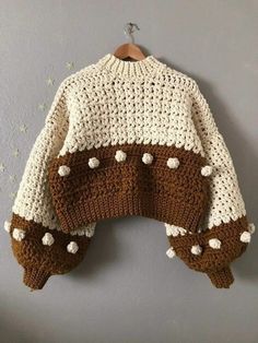 a brown and white sweater hanging on a wall