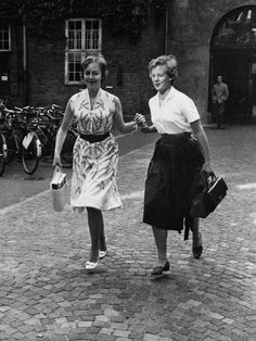 two women walking down the street holding hands