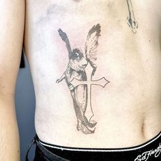 a man with a cross and angel tattoo on his stomach