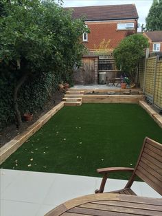 a backyard with artificial grass and wooden furniture