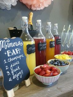 there are many different types of drinks on the table with chalkboard signs in front of them