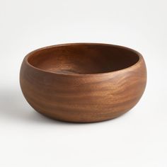 a wooden bowl sitting on top of a white table