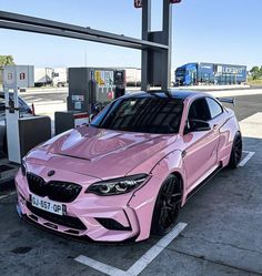 a pink car parked at a gas station