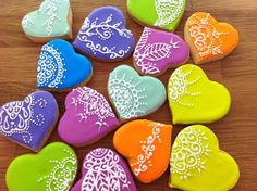 decorated heart shaped cookies sitting on top of a wooden table