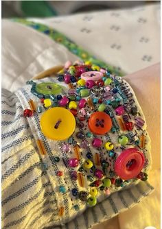 a close up of a person's arm wearing a bracelet with buttons on it