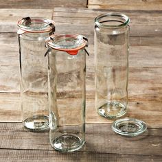 three empty glass jars sitting on top of a wooden table