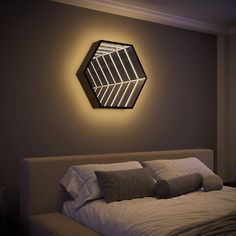 a bed sitting under a mirror in a bedroom next to a wall mounted light fixture