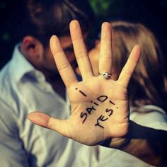 a man and woman holding up their hand with the word i love you written on it