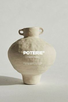 a white vase sitting on top of a table next to a gray wall with the words poterie written on it