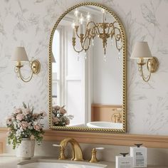 a bathroom with a sink, mirror and flowers in the vase on the counter top