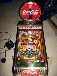 an old fashioned coca cola machine sitting on the floor